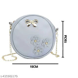 Pastel pink crossbody bag with floral design, round purse shape, gold zippers, and a chain strap