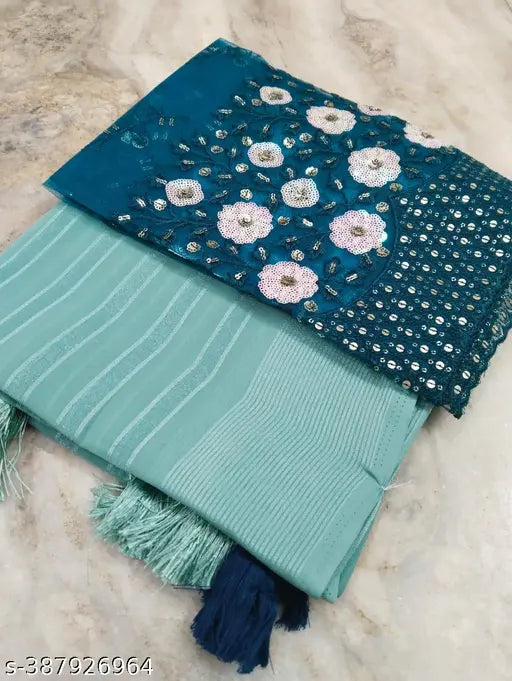 Shimmering teal georgette sari with embroidered net blouse