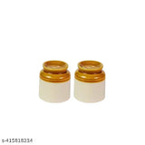 The image displays a pair of cylindrical ceramic containers with metal lids, each containing what appears to be granular salt or pepper. These containers are white and have a textured surface. They are labeled as "Ceramic Martban 4000 kg" and "Achaar Barni." One container is slightly off-center in the image