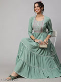 A woman sitting on a chair wearing a long sleeved, rayon embroidered, round neck kurta with ruffled ankles