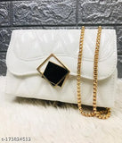 White leather cross body bag with gold chain details and a black diamond-shaped hardware accent