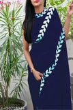 Woman in dark blue sari standing outdoors, traditional attire with gold border