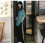 Teen fashion model in black cap and blue hoodie with sneakers, standing by doorway