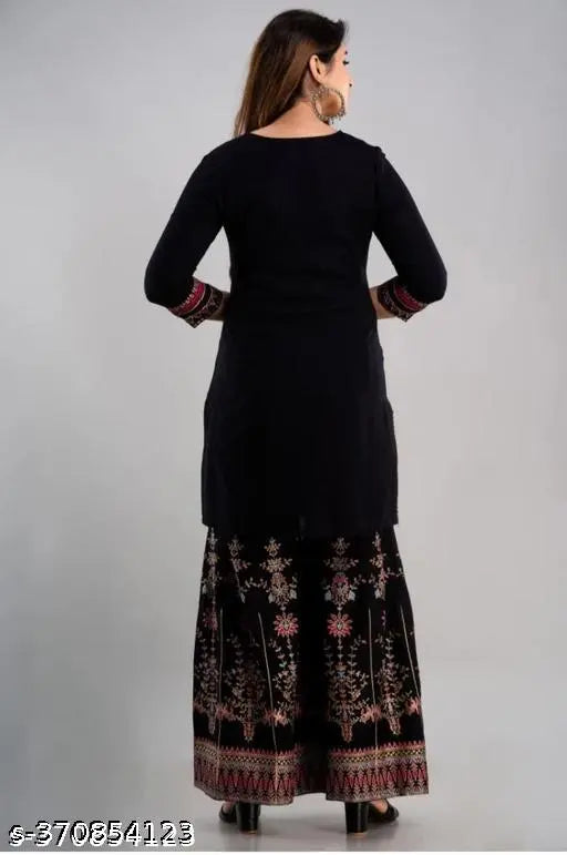 Black rayon sharara set from Jeevika Fashion, printed with intricate design, includes dupatta and bottomwear. Three-quarter sleeves, available in multiple sizes. Made in India