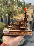 A small intricately designed replica of a wooden temple-like structure, inspired by traditional Indian architectural styles. Displayed against a neutral background