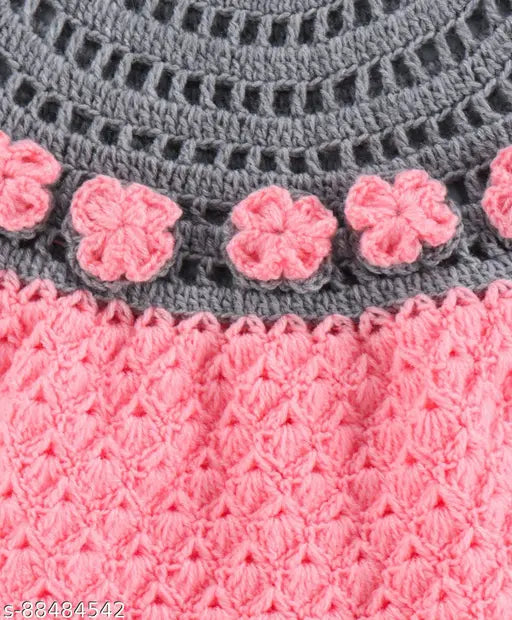 Grey crocheted dress with pink floral trim, matching hairband, and pair of coral-colored booties