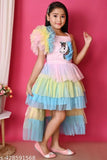 A girl wearing a multicolored rainbow unicorn dress with frilly sleeves and ruffled bottom