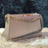 Women's embroidered sling bag with beige background and chain detail