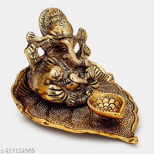 Gold metal Ganesh sitting on pipal leaf with diya, decorative showpiece for home/office/gifting - 3 cm (India)