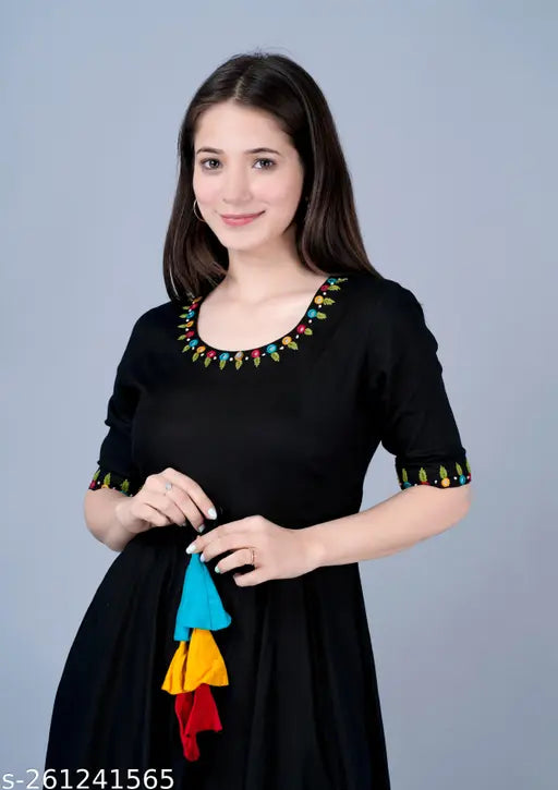 Black kurta with embroidered neckline, mirrored border detail, and sharara set, featuring traditional South Asian fashion