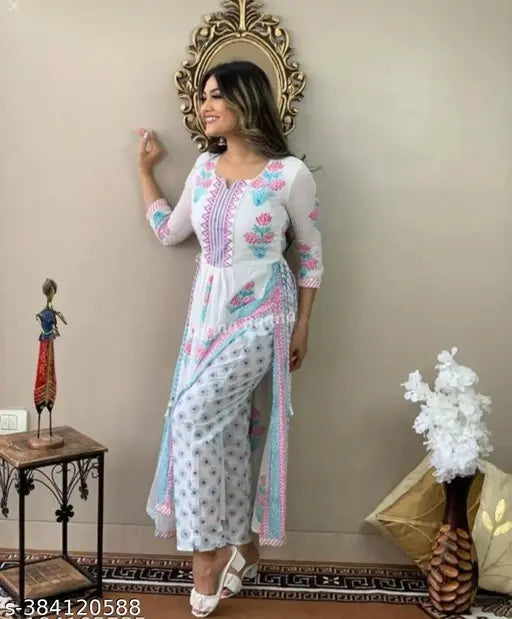 A woman poses in a traditional kurta and pant set, featuring floral embroidery on a light fabric