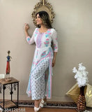 A woman poses in a traditional kurta and pant set, featuring floral embroidery on a light fabric