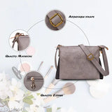 Grey sling bag with gold buckle and adjustable straps