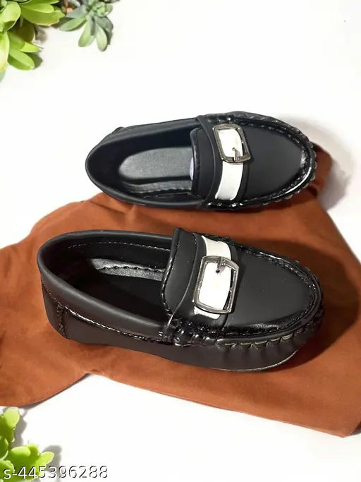 Black leather loafer shoes, with silver buckles and a shiny patent finish