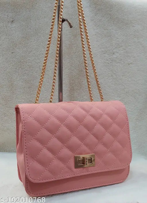 Cross body bag with pink quilted exterior, gold chain strap and black hardware accents
