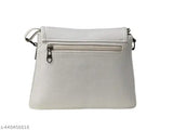 White sling bag with silver zippers and straps