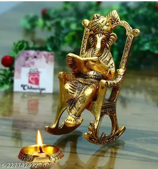 Metal Ganesha figurine, seated on a chair reading Ramayan. Decorative showpiece for corporate gifts or home decor. Indian origin. Product dimensions: 10cm (L) x 10.5cm (H) x 10cm (B), Net Quantity: 1
