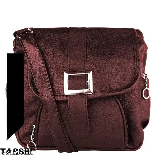 A burgundy leather sling crossbody bag with a metal buckle