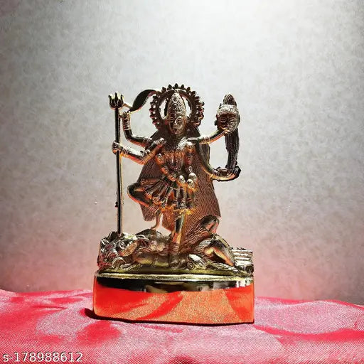 Metal deity statue with blue cloth draped over, intricate detailing
