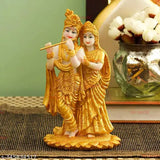 Resin Radha Krishna statue sculpture with gold plating, diya, black tray, and multi-colored stones. Ideal for home decor, living room, or temple use. Indian origin
