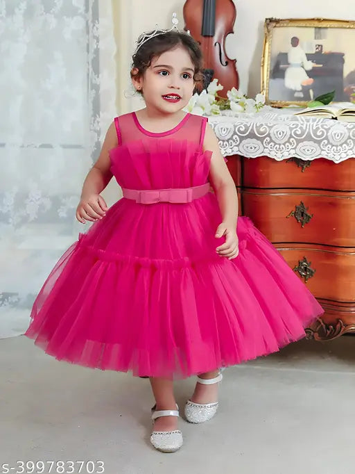Girl wearing a pink, floor-length tutu dress with a fitted top and strap details