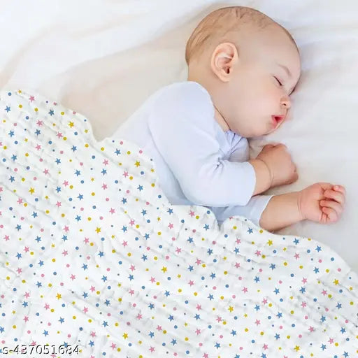 Cute baby sleeping in a blue and white star muslin swaddle, organic cotton 4705168.