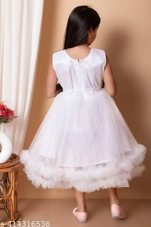 A young child wearing a white, lacy knee-length girls' frock with ruffles at the hem. The dress features short sleeves and a round neckline