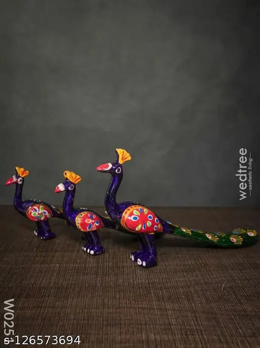 Multicolored peacock craft decorations, set of three, hand-painted with vibrant colors on a dark background