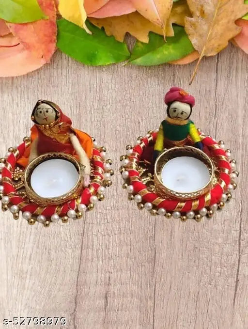 Small, colorful ceramic tea light candle holders decorated with Indian puppet design. Contains a small white candle