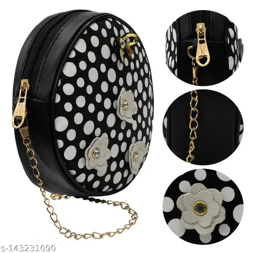 A black crossbody bag with polka dot accents, sling strap, and a decorative clasp