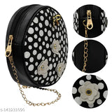 A black crossbody bag with polka dot accents, sling strap, and a decorative clasp