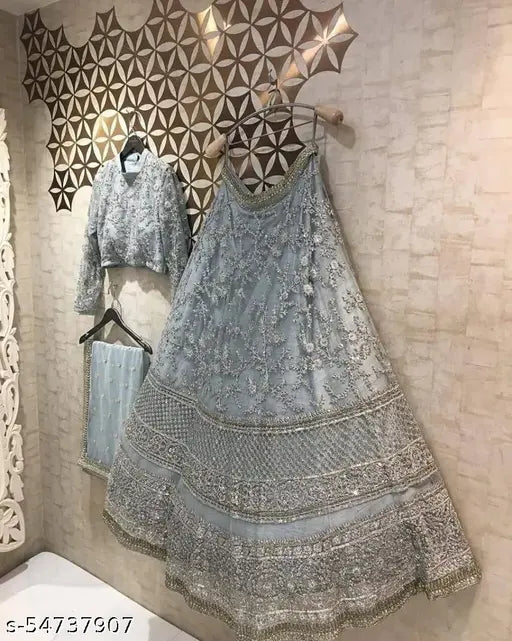 Attractive net lehenga choli and dupatta set, embellished with intricate embroidery. Semi-stitched, free size (waist 68m, length 42m, dupatta 2.7m). Handcrafted Indian bridal wear