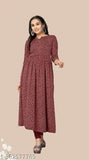 A woman wearing a long-sleeved printed kameez with a flared skirt. The kameez has a mix of dark and light colors, featuring a pattern on a crepe fabric. It is presented in a display setting
