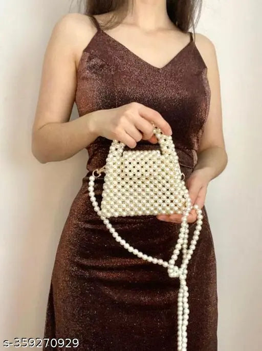 A woman wearing a sparkly dress holds a decorative white button clutch, suggesting a party accessory