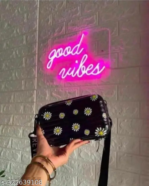 Pink neon sign with 'Good vibes' in white letters, against pink wall