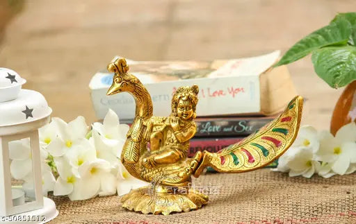 Golden metal sitting idol of Lord Gopal on a peacock, showcased as a puja item, for vastu decoration