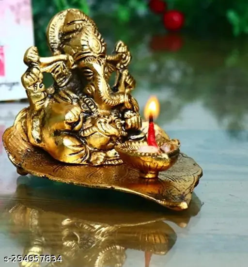 Metal Ganesha statue with diya, sitting on leaf, handcrafted for home decor, Indian artifact
