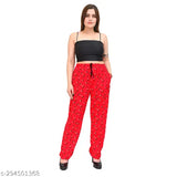 A person is wearing a dark-colored top and red cotton pants with visible design details. The attire features loose, elasticated bottoms and lower waistlines, possibly suggesting a casual style for women's clothing