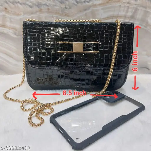 Black croc leather sling bag, featuring a crossbody strap and attached hanging chain, with gold-tone hardware