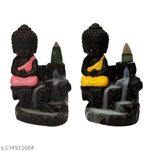 Colorful stone monk statue with a smoke fountain, sitting on a base holding sticks