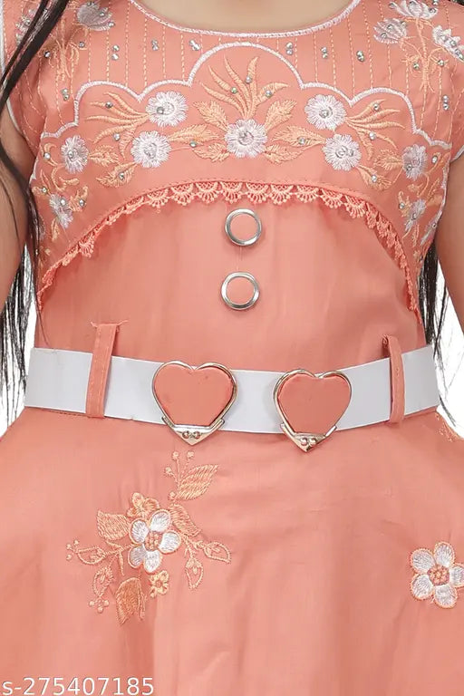 A girl's pink frock with embroidered details and a belt