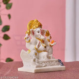 Marble statue of Lord Ganesha with gold jewelry, seated on a wooden boat