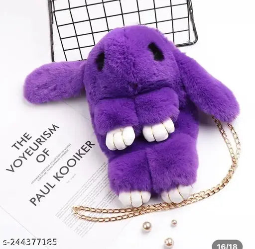 Purple plush toy in the shape of a rabbit, attached to a gold chain necklace, against a white background with scattered blue and green objects