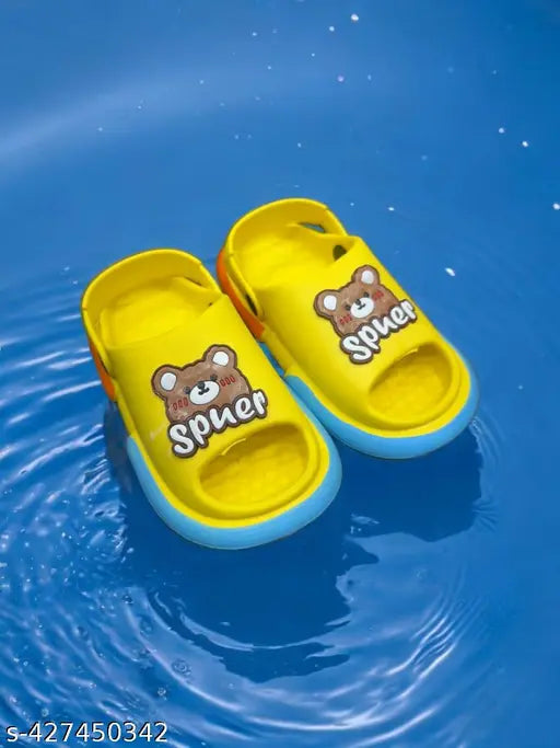 Children's slippers in yellow with a teddy bear on them, floating on blue water