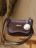 A brown leather purse with a fuzzy tassel and metal hardware, featuring multiple card slots