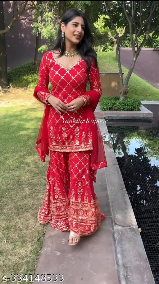 Red and gold embroidered party wear look for women, including dupatta set