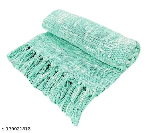 A soft, light blue fringed throw blanket on display
