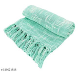 A soft, light blue fringed throw blanket on display