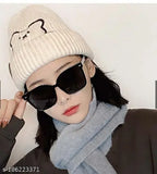 This is a knitted beanie hat with an embroidered bear design, worn by a person. The background is white and out of focus
