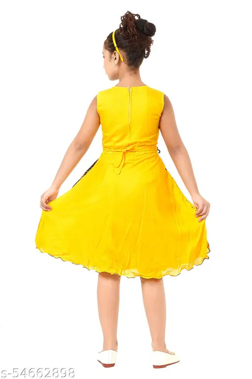 This is a photo of an individual wearing a yellow, knee-length dress with puff sleeves. The dress has ruffled detailing along the waistline. The person is also wearing black shoes and has short hair